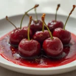 air fryer cherries roasted: Glossy roasted cherries in an air fryer basket, juicy and glistening with syrup, perfect for Air-Fryer-Baking-Sweets