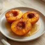 air fryer grilled peaches: Golden grilled peach halves with caramelized surface and char marks in air fryer basket