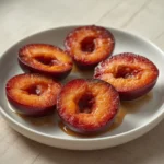 air fryer plums roasted: Juicy roasted plums in an air fryer basket with a caramelized, glossy finish and warm cinnamon aroma.