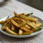 air fryer okra fries: Golden crispy air fryer okra fries on a plate, with crisp edges and savory seasoning.
