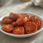 air fryer turkey kielbasa: Golden, crispy turkey kielbasa slices in an air fryer basket with smoky paprika seasoning.