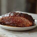 Air Fryer BBQ Beef Brisket: Juicy air fryer BBQ beef brisket with glistening caramel-brown glaze and crisp edges on a plate.