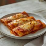 Air Fryer Chicken Enchiladas: Golden air fryer chicken enchiladas with melted cheese and crispy edges on a white plate