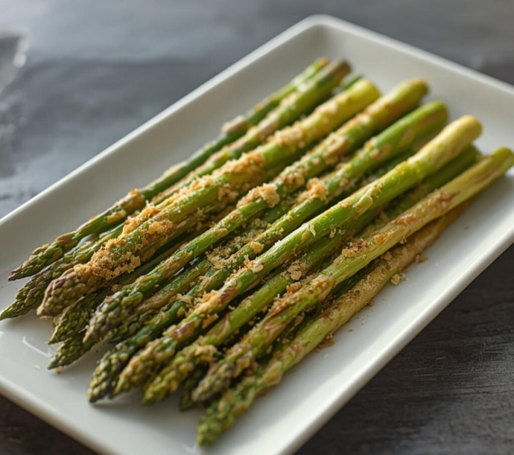 Golden brown and green air fryer asparagus spring spears perfectly cooked on a white rectangular plate.