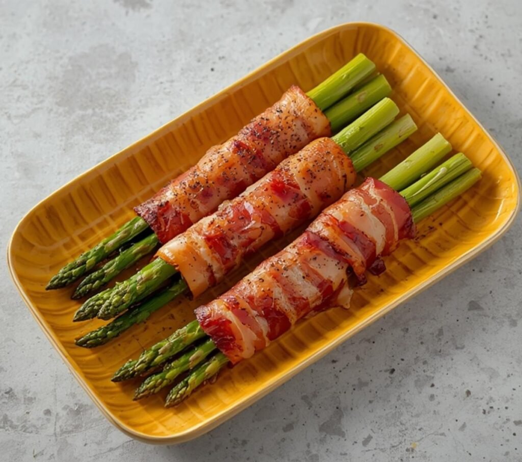 A platter of perfectly cooked air fryer bacon wrapped asparagus, ready to be served.