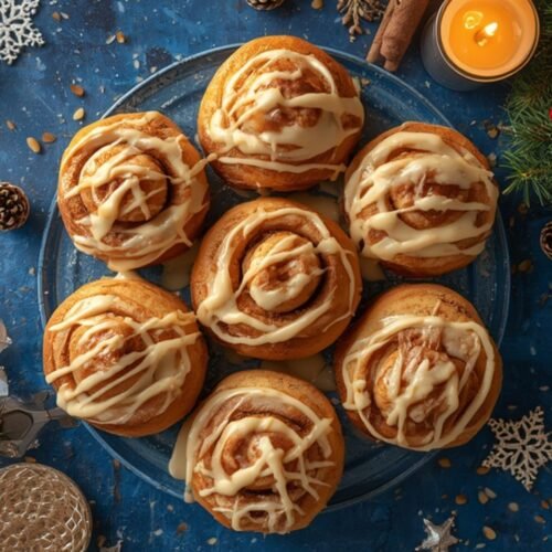 A festive overhead shot of freshly baked Air Fryer Cinnamon Rolls on a dark background
